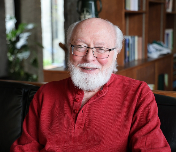 A man wearing red smiling at camera.