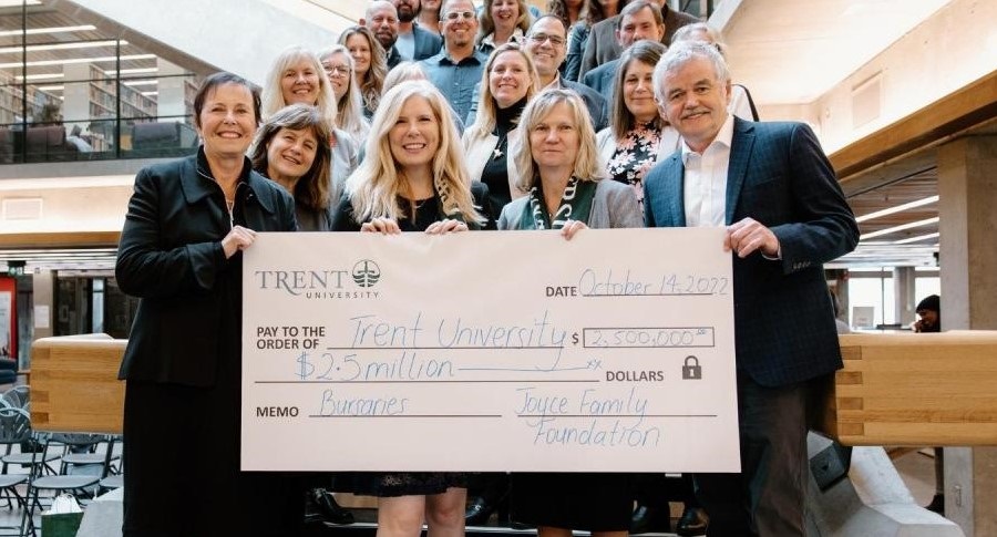 A group of Trent University's leaders celebrating a new $2.5M gift on the stairs of the Bata Library.