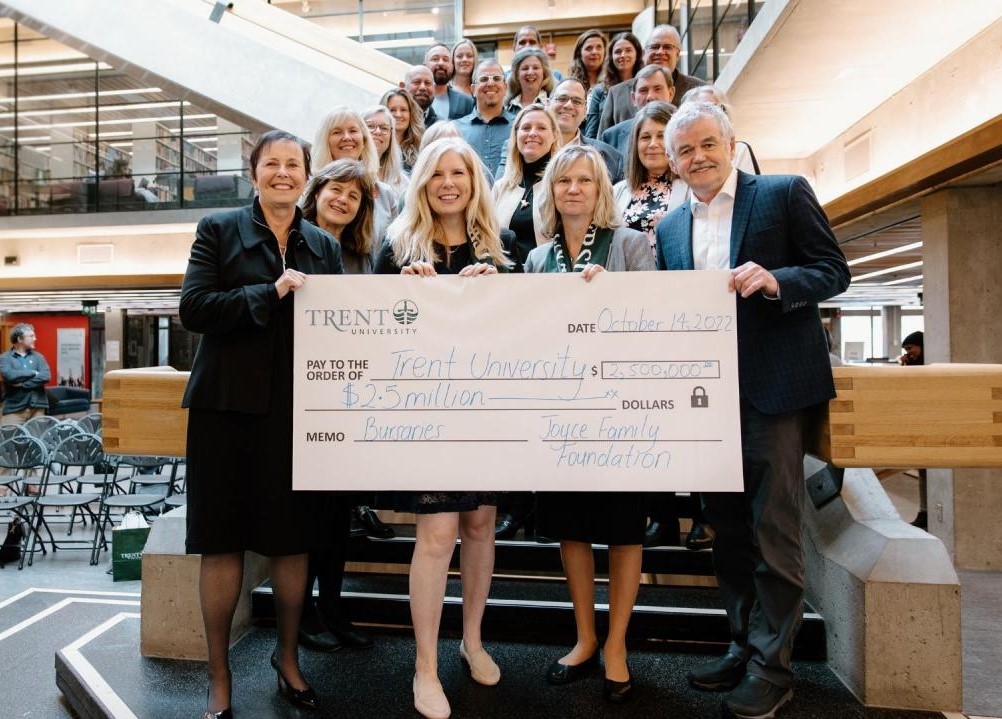 A group of Trent leaders celebrating a new gift on the stairs of the Bata Library