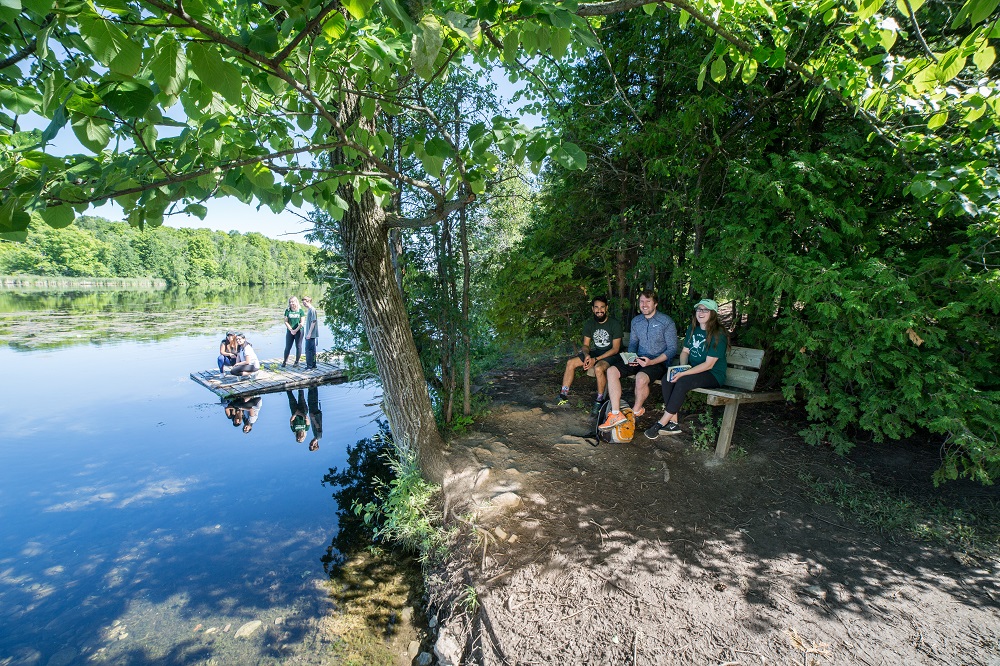 People on bench and dock at lake