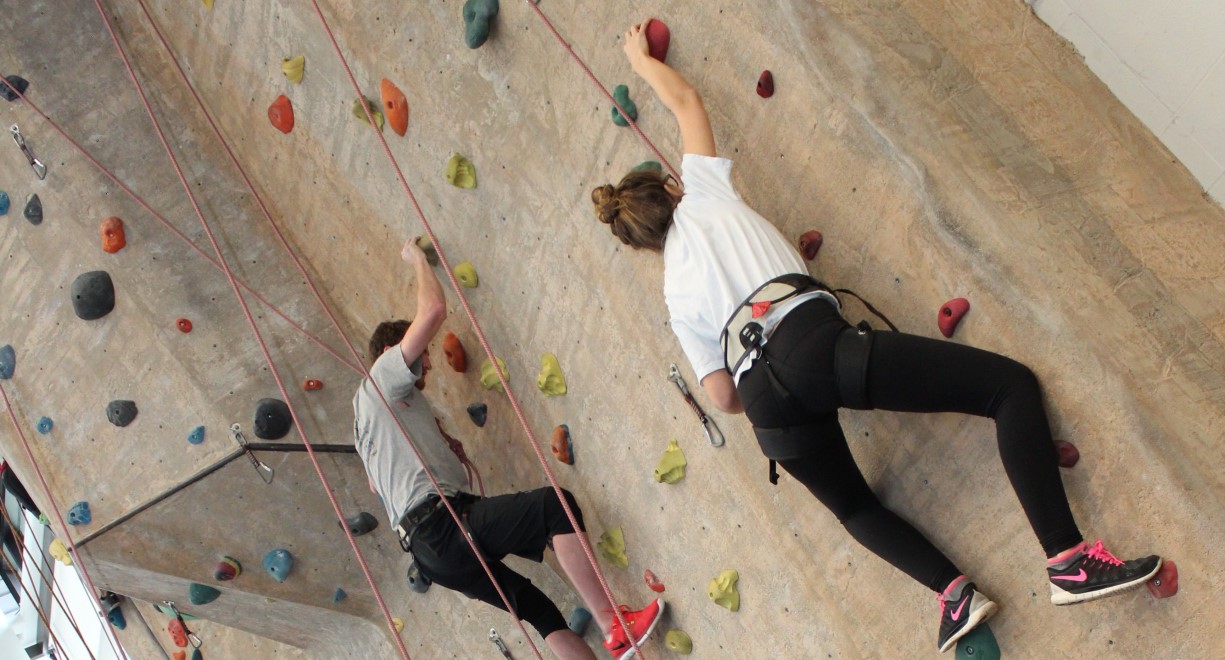 Two people on a rock climbing wall